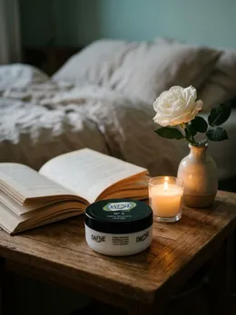 Crema N°5 sul comodino con libro e candela